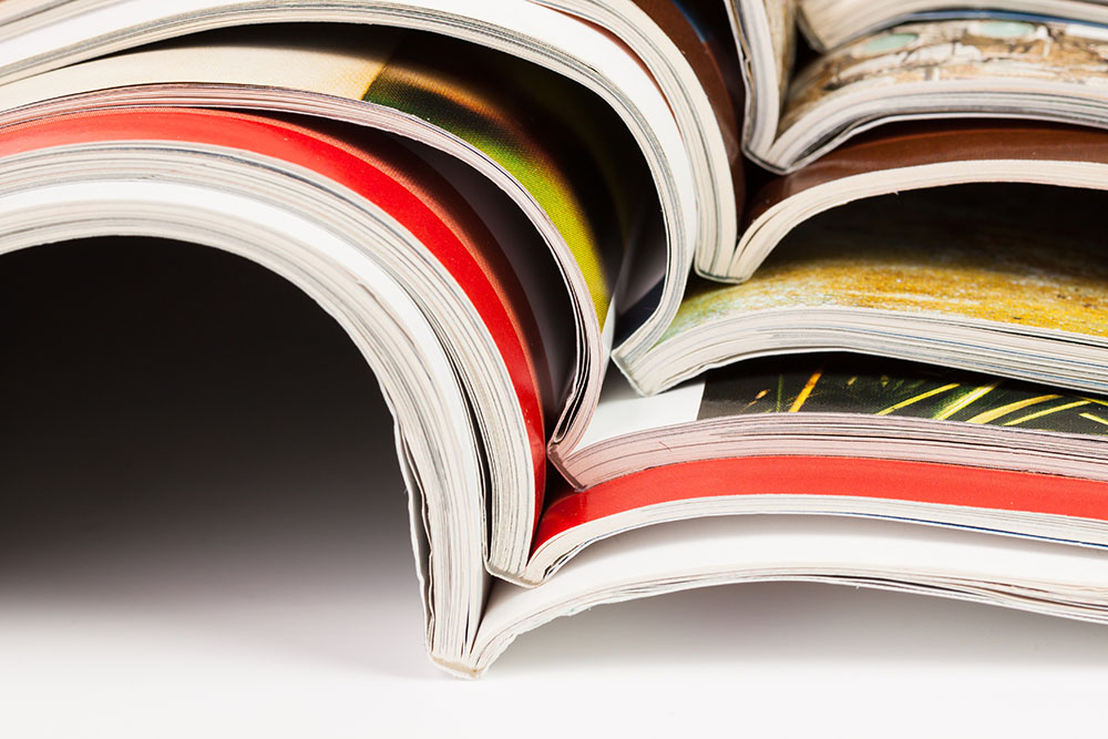 Stack of color magazines on white background